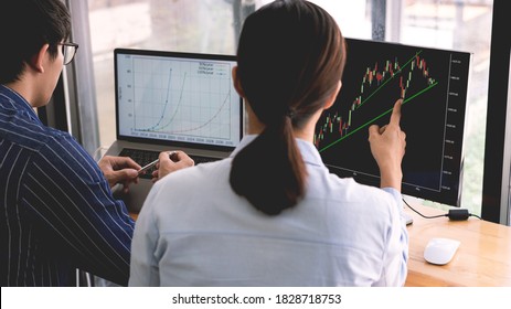 broker showing some ascending to his colleague planning and analyzing graph stock market trading with stock chart data on multiple computer screens - Shutterstock ID 1828718753