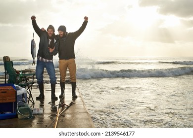 Bromance Blooms Over A Fishing Trip. Shot Of Two Young Men Fishing Off A Pier.