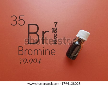 Bromine is a chemical element of the periodic table with the symbol Br and atomic number 35. The symbol Br with atomic data and reddish-brown liquid bromine solution in the background.