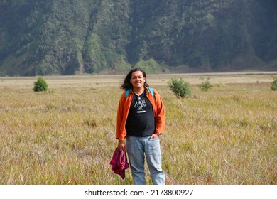 Bromo 26 June 2022 - Asian Guy With Long Hair Is Having Portrait Photo With A Beautiful Nature Background In Tengger District East Java During Holiday