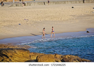 BRONTE, NSW / AUSTRALIA - DECEMBER 30, 2014: Two Women Walking In Opposite Directions On Bronte Beach