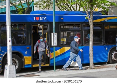 BRONX, NEW YORK, USA - May 18, 2020: People Getting Off City Bus While Wearing Masks Against Covid.