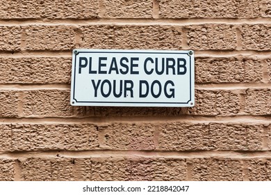 The Bronx, New York, USA. Please Curb Your Dog Sign On A Brick Wall.