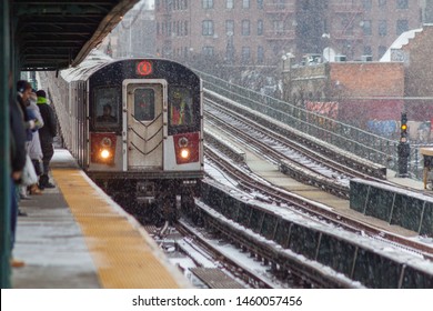 Bronx, NY/USA - December 14, 2013: Commuters wait for arriving number 4 train on a snowy day at the Mosholu Parkway station in the Bronx.