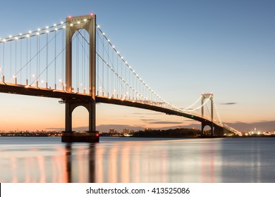 The Bronx-Whitestone Bridge reflecting on the East River at night in New York.