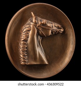 Bronze basrelief of a horse on a black background