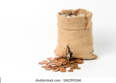 Bronze coins drop and leaking from torn brown money bag made from hemp sack, isolate on white background with copy space, concept of loosing money from investment and business.