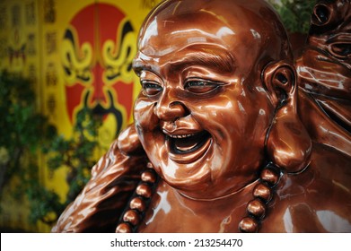 Bronze Coloured Budai Statue at a Taoist Shrine - Budai is Commonly Known as the Laughing Buddha