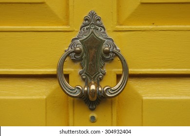 Bronze Door Knocker On A Yellow Door