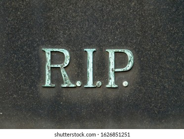 Bronze Letters Saying R.I.P On A Tombstone