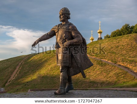 Bronze monument to Yuri Dolgoruky on earthen ramparts background of ancient Kremlin, Dmitrov, Moscow Region, Russia