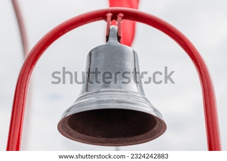 Bronze old bell on red holder in a boat - Close up