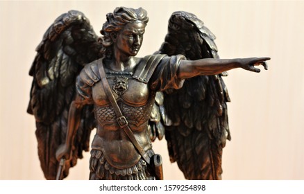 bronze sculpture of Archangel Michael with wings and sword