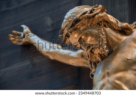 Bronze sculpture of crucified Jesus. Selective focus area.