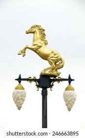 Bronze sculpture of a horse standing on a light pole.