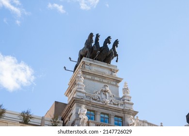 Bronze Sculpture Of A Quadriga On The Top Of A Classical And Historical Building At Alcalá Street, In Downtown Madrid, Spain.