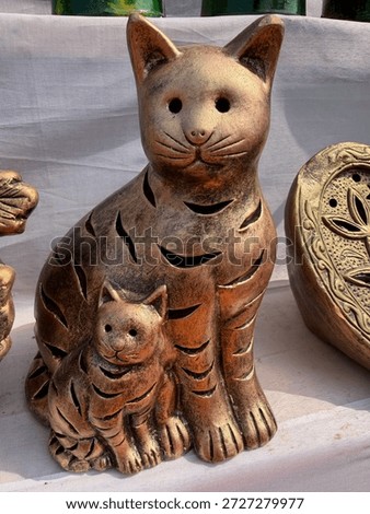 Bronze-finished ceramic cat and kitten lanterns with decorative cut-outs.
