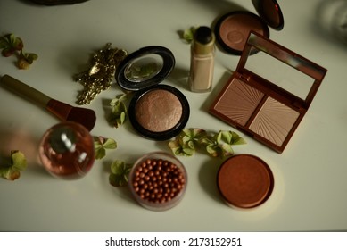 bronzer, highligher and face powder on a table. concept of summery makeup colors and choice of face makeup