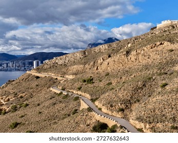 brooding clouds gathering above rugged cliffs, dramatic light and shadow amplify raw textures, scene evokes