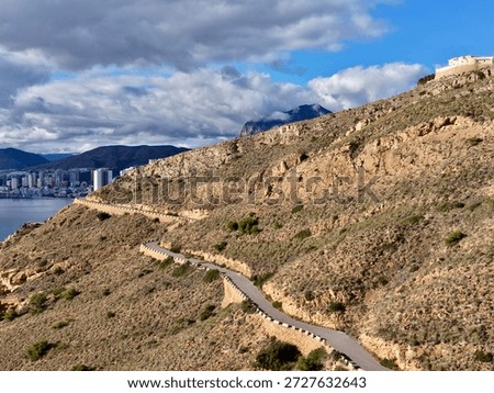 brooding clouds gathering above rugged cliffs, dramatic light and shadow amplify raw textures, scene evokes