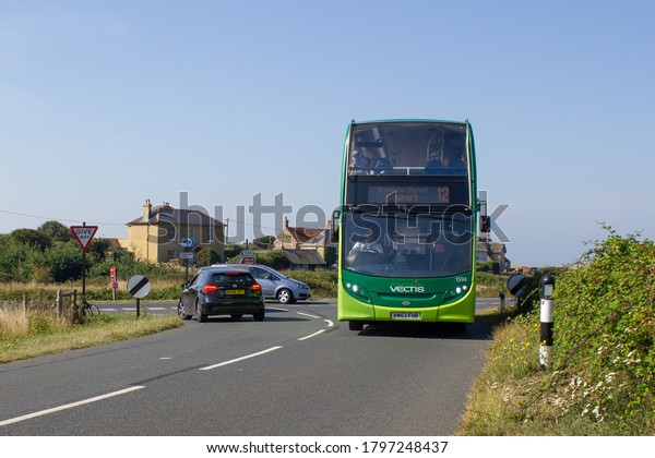 BROOK CHINE, ENGLAND - AUGUST 11 2020: A\
Southern Vectis bus approaches a bus stop at Brook Chine with a\
service bound for Newport, Isle of Wight,\
England.
