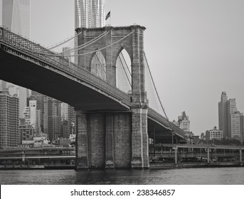 The Brooklyn Bridge in black and white with New York City in the background.
