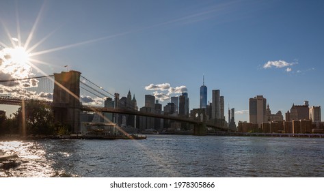 Brooklyn Bridge, East River And Lower Manhattan In Background. NYC Skyline. Bright Sunny Day And Sunlight. Dumbo. Sightseeing Place Among Locals And Tourists In NYC.