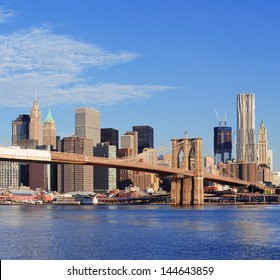 Brooklyn Bridge With Lower Manhattan Skyline Panorama In The Morning With  Cloud And Blue Sky Over East River In New York City