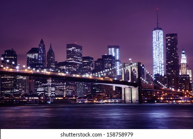 The Brooklyn Bridge On A Colorful Night. Photo Features The NYC Skyline And One World Trade Center