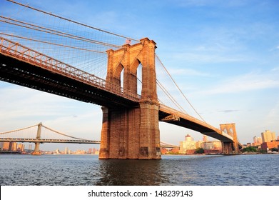 Brooklyn Bridge over East River viewed from New York City Lower Manhattan waterfront at sunset. - Powered by Shutterstock