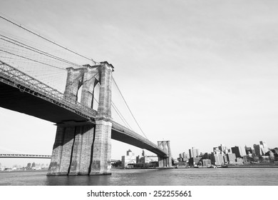 Brooklyn Bridge over East River viewed from New York City. Black and white.