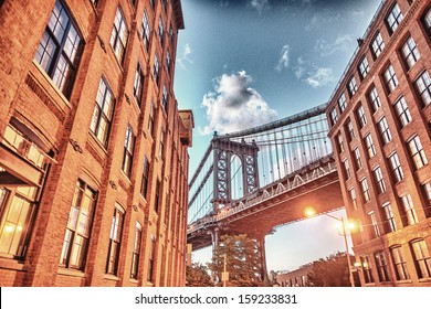 Brooklyn Bridge Seen Among City Buildings At Night.