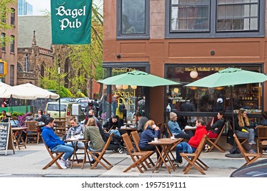 Brooklyn, New York - April 17 2021: diners enjoy bagels and coffee as they sit outside in the Park Slope neighborhood of Brooklyn.