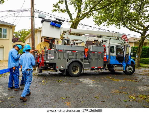 BROOKLYN, NEW YORK - AUGUST 6,\
2020: Con Edison repair crew restores power and clears street the\
aftermath of severe weather as tropical storm Isaias hits New York\
City 