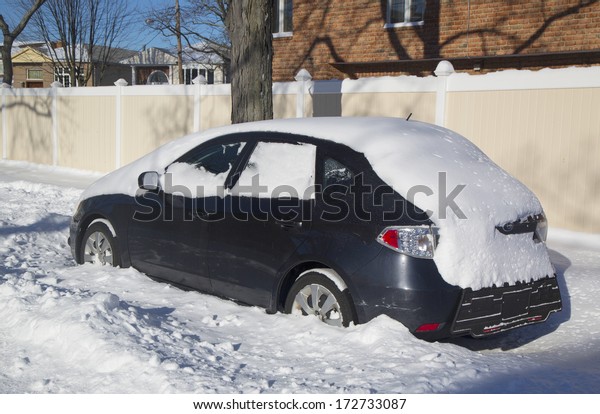 BROOKLYN, NEW YORK - JANUARY 22: Car under snow on\
January 22, 2014 in Brooklyn, NY after massive Winter Storm Janus\
strikes Northeast. Foot of snow hits NYC as Northeast reels from\
Winter Storm Janus