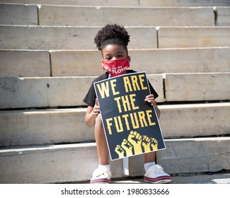 Brooklyn, New York, United States - May 23, 2021 - A child holds a "We Are the Future" sign during the launch of the We Are Floyd organization in memory of George Floyd.