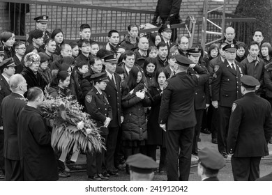 Brooklyn, NY - January 04, 2015: Pei Xia Chen widow of Wenjian Liu cries while holding colors outside Aievoli Funeral Home for the funeral of slain New York City Police Officer Wenjian Liu