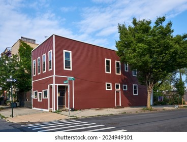 Brooklyn, NY - July 5, 2021: A Small Two-story Residential Building With Red Siding And White Trim In In Red Hook Brooklyn, NYC. This Old Building Was Formerly A Commercial Store Front,