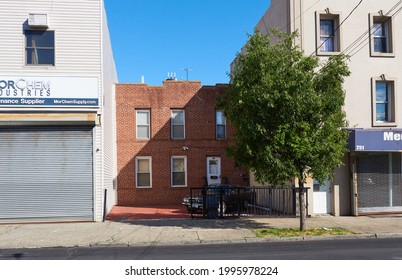 Brooklyn, NY - May 31 2021: 249 Van Brunt St Is A Small Two Story Brick Residential Building Set Back From The Larger Storefronts Buildings That Surround It In The Red Hook Neighborhood Of Brooklyn