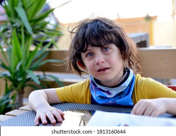 Brooklyn, NY, US - July 15, 2020: A Tearful Young Girl Looks Up From Her Apple IPad Tablet Device At An Outdoor Restaurant During The COVID-19 Pandemic.