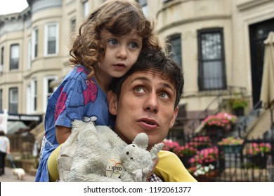 Brooklyn, NY, US - Sept. 13, 2018: A Little Girl Sitting On Her Father's Shoulders Put An 