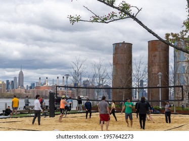 Brooklyn, NY - USA - April 17, 2021: A View Of People Enjoying  A Game Of Volley Ball At Domino Park's Beach Volleyball Court. A Public Park Located On The East River In Williamsburg.
