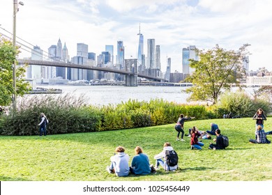 Brooklyn, USA - October 28, 2017: Dumbo Outside Exterior Outdoors In NYC New York City, People In Green, Urban Main Street Park, Cityscape Skyline And Bridge With East River