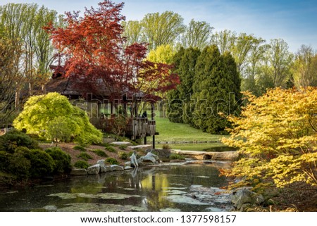 Brookside Gardens, Glenmont (Silver Spring) Maryland, with beautiful spring bloom and red leaf trees, surrounding a small lake and gazebo.