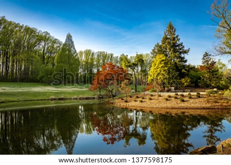 Brookside Gardens, Glenmont (Silver Spring) Maryland, with beautiful spring bloom and red leaf trees, surrounding a small lake and gazebo.