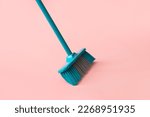 Broom for cleaning on pink background