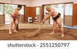 Broom, dohyo and sand of Sumo wrestler people in mawashi, getting ready for competition. Cleaning, preparation and start with Japanese men for culture, local heritage or martial arts tradition