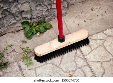 Broom Standing Near Wall Outside. Close Up