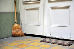 Broom At The White Wooden Door