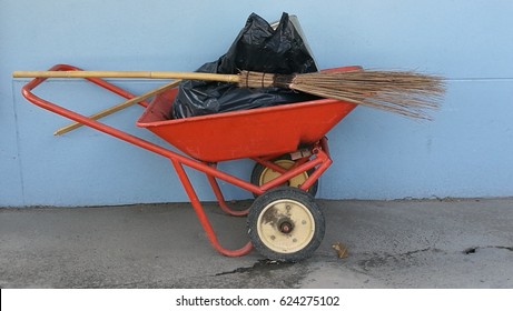 Brooms,garbage Bags On The Waste Cart With Blue Wall Background.Cleaning Equipment Concept.